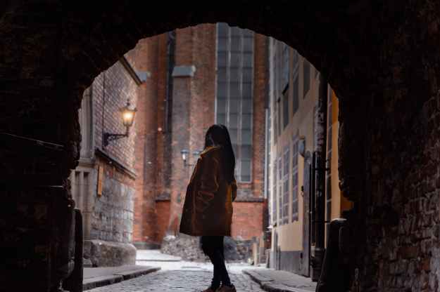 woman standing inside alley tunnel